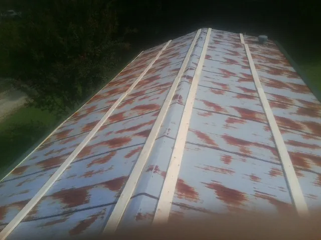 Rusted metal roof panels with new wood purlins before replacement — Storm Damage Roof Repair in Grand Haven by Roofing Brothers