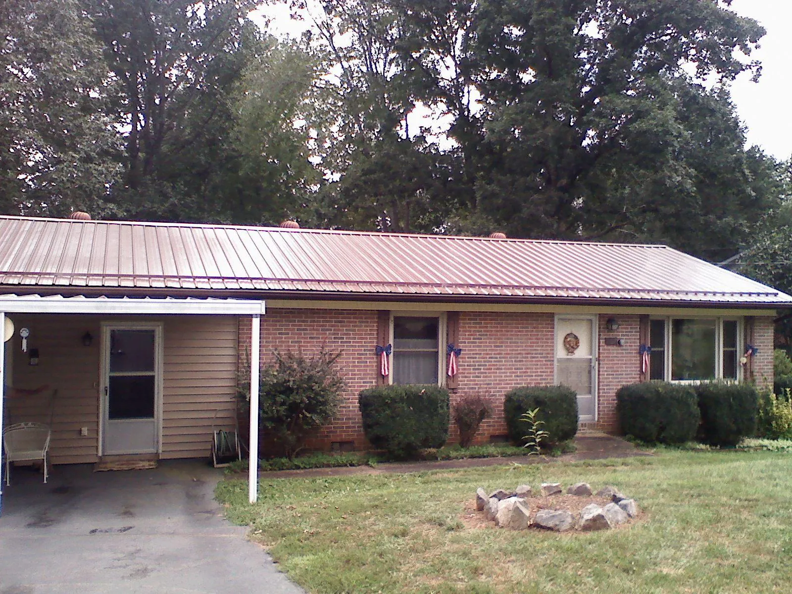 Bronze metal roof and carport on a brick ranch home — Roof Repair work by our crew in Grand Haven